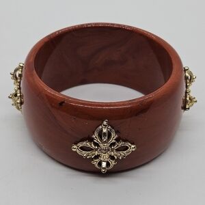wide red-orange acrylic bangle bracelet with gold tone details